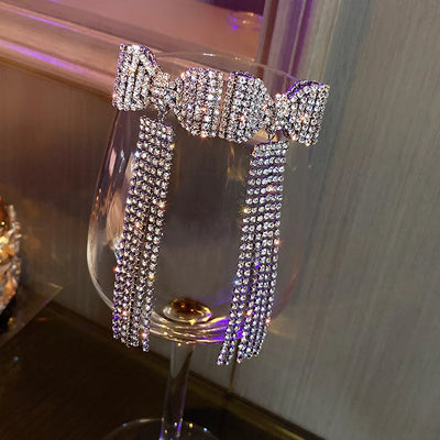 Selena - Boucles d'oreilles glamour avec nœud en cristal et pompon